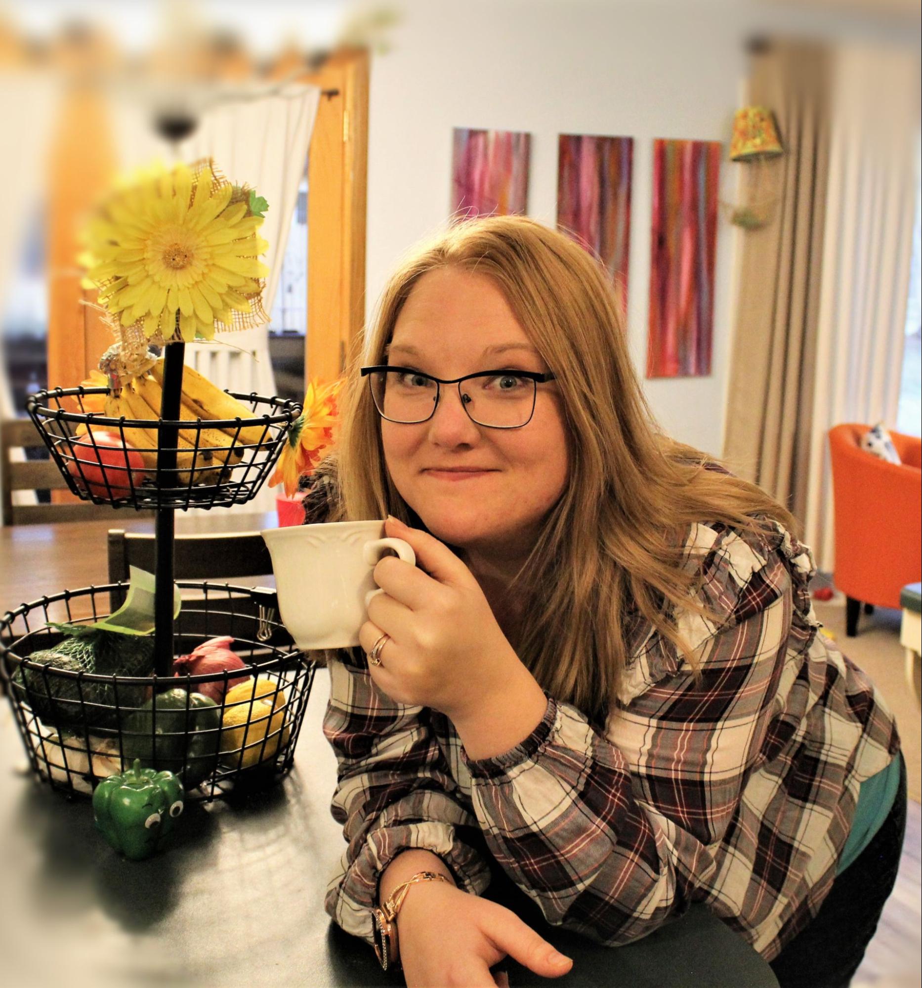 Mrs. Mhm resting on the counter drinking coffee next to her fruit and veggie holder